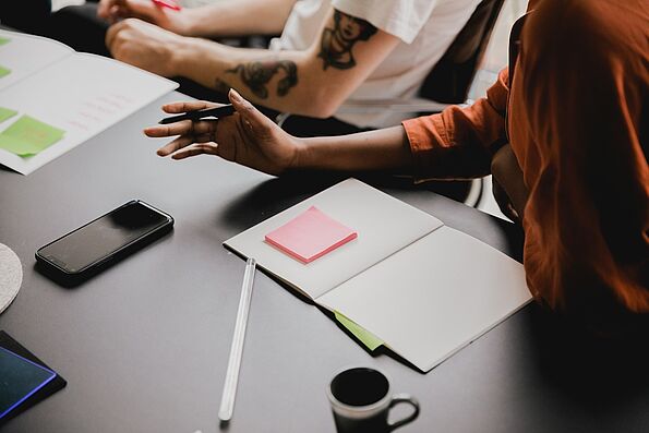 Foto von einem Schreibtisch, auf dem ein Notizbuch liegt
