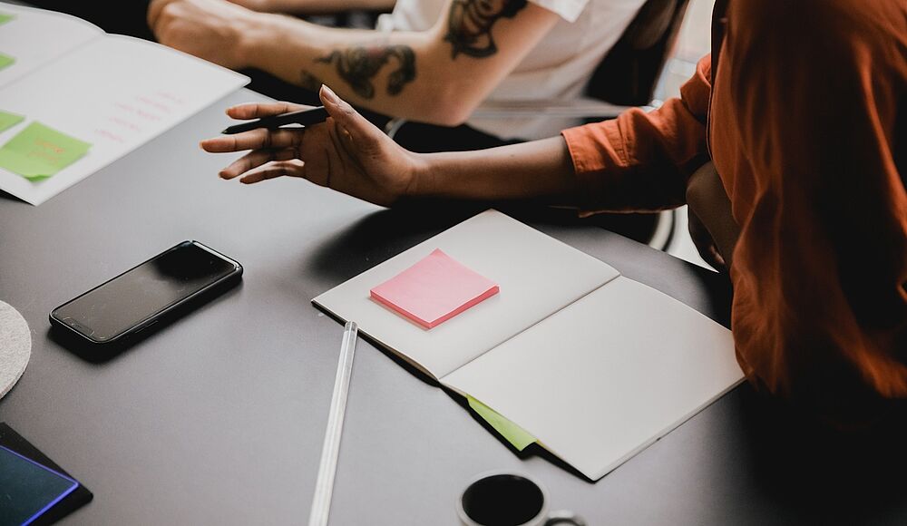 Foto von einem Schreibtisch, auf dem ein Notizbuch liegt