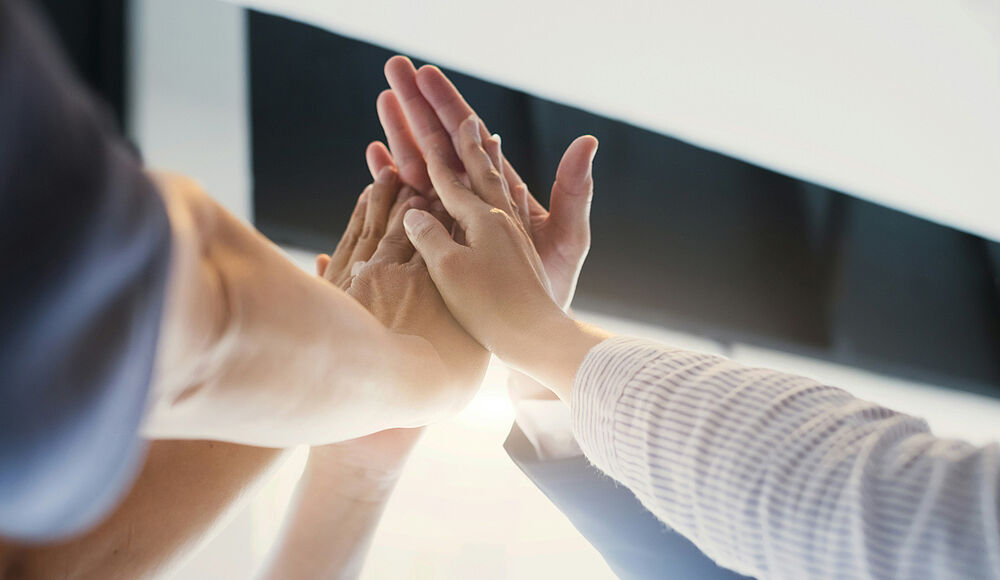 Titelbild: Hände, die sich in der Mitte treffen