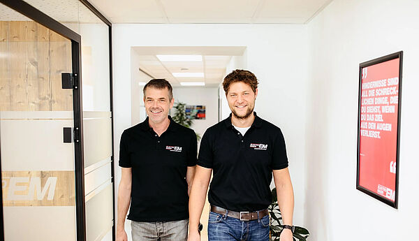 Zwei Männer stehen mittig in schwarzen Elektro-Maier T-Shirts